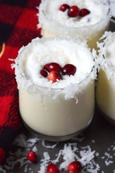 three desserts with cranberries and coconut in them on a tablecloth,