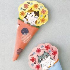 two paper cones with cats and flowers on them