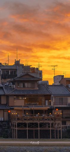 an orange and yellow sky over some buildings