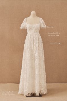 an image of a dress on display in front of a beige background with words describing the details