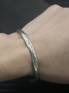 a person wearing a silver bracelet on their arm