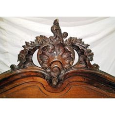an ornate wooden bed frame with carvings on the headboard