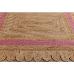 a pink rug with scalloped edges on a wooden floor