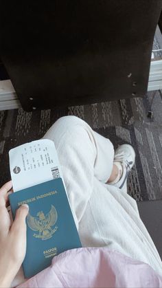 a person sitting on the floor holding a passport
