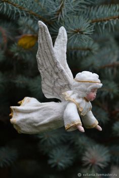 an angel ornament hanging from a christmas tree