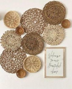 several different types of woven doily are arranged on a white wall with a sign