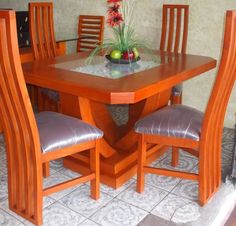 a wooden table with chairs around it and a vase on top of the dining room table