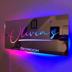 a neon sign that is on the side of a wall next to a bed room