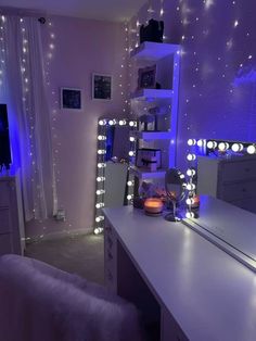 a bedroom with lights on the walls and a desk in front of a mirror that is lit up