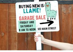 a hand holding a sign that says buying new is lame garage sale friday and saturday 8 am to noon 123 main street