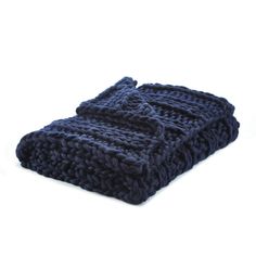 a blue knitted blanket laying on top of a white surface
