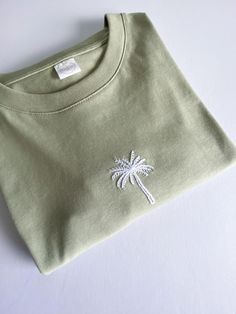 a t - shirt with a palm tree embroidered on it