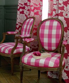 pink and white striped chairs in front of red curtained windows with flowers on them