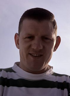 a man in striped shirt smiling at the camera