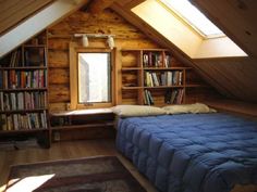 an attic bedroom with bookshelves and a bed