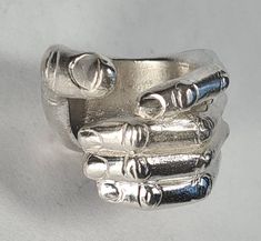 **Please note that we dispatch on Tuesdays unless special delivery express option is paid for** Sterling silver 'hand ring'. Original design carved in wax then lost wax cast into sterling silver.  Very large piece which weighs approximately 42g in silver.  Shown in a size S, and adjustable to ring sizes P-V.  A significant size adjustment may alter the appearance. PLEASE NOTE THE PHOTO ON THE WOMAN IN THE REVIEW IS A SIZE J AND TO MAKE IT LOOK LIKE THAT AT A LARGER SIZE WILL REQUIRE A £40 SUPPLEMENT. Please contact us to discuss.  First class recorded post included, with a supplement for special delivery. Artisan Silver Rings, Asymmetrical Ring, Cool Rings, Ring Tattoos, Friendship Rings, Dope Jewelry, Stylish Rings, Hand Ring, Big Rings