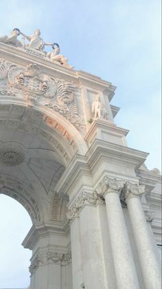an ornate white archway with statues on top