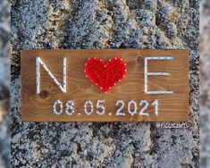 a wooden sign that says noe with a red heart on it and the word love spelled in white letters