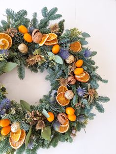 Seasonal winter wreath of Abies, eucalyptus, blue eryngium, dried orange slices, kumquat and walnut. Added a touch of gold. Orange Blue Christmas Tree, Yellow Christmas Wreath, Colourful Wreath Christmas, Burnt Orange Christmas Tree Decorations, Wreaths With Oranges, Orange And Blue Wreath, Blue And Orange Wreath, Blue Orange Christmas Tree, Orange And Blue Christmas Decor