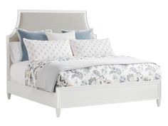 a white bed with blue and white pillows on it's headboard, in front of a white background