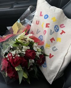 a bouquet of flowers sitting in the back seat of a car next to a paper bag