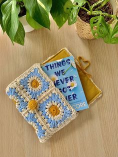 two crocheted coasters sitting on top of a table next to a potted plant