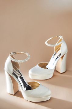 a pair of women's white high heeled shoes with pearls on the ankle