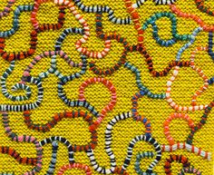 a close up view of some beads on a yellow surface