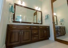 a bathroom with two sinks and mirrors in it