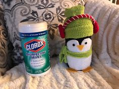 a stuffed penguin sitting next to a bottle of clorox disinfecting wipes