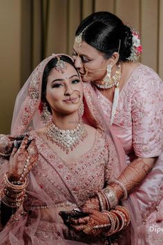 two women dressed in pink posing for the camera with their hands on each other's shoulders