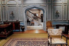 an ornately decorated living room with blue walls and wood flooring is seen in this image