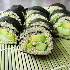 sushi rolls with avocado and sesame seeds are on a bamboo mat, ready to be eaten