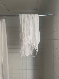 a white shower curtain hanging in a bathroom