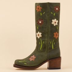 These cowgirl boots feature a dark green hue, square toe design, block heel for comfort, and blossom detailing around the mid-calf area, blending classic Western style with contemporary flair. Color: Dark green Heel Type: Block heel Heel Height: 2.36" / 60 mm approx Shaft Height: 11.81'' / 300 mm approx Product measurements were taken using size 8. Please note that measurements may vary by size. Toe: Square toe Flower blossom design Pull-on design Handcrafted US sizing. Fits true to size. Casual Cowgirl Outfits, Sunflower Cowgirl Boots, 70s Shoes, Hippie Shoes, Retro Boots, Cowboy Boots For Women, Flower Boots, Hippie Boots, Green Heels