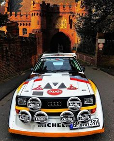 an old race car parked in front of a castle