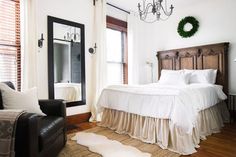 a white bed sitting next to a window in a bedroom