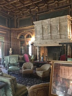 an ornately decorated living room with many chairs and paintings on the walls, along with a fireplace