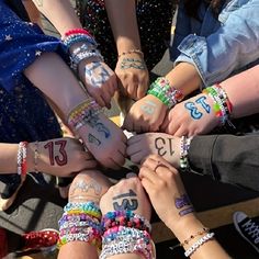a group of people holding hands with numbers painted on their arms and wristbands