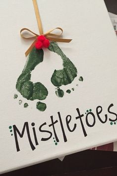 a handprinted christmas card with the word mistle toes on it and a ribbon
