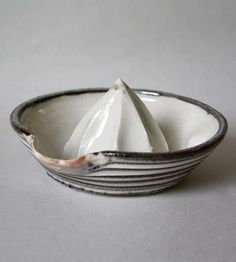 a black and white bowl with four napkins in the middle, on a white background