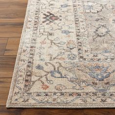 a large rug with an ornate design on the top and bottom, sitting on a wooden floor