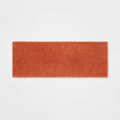 an orange rug on a white surface with no one in the room to see it