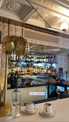 the bar is decorated with gold and white decor, including a palm tree in front of it