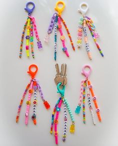 several pairs of colorful beaded keychains on a white surface