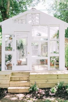 a small white house sitting on top of a wooden deck