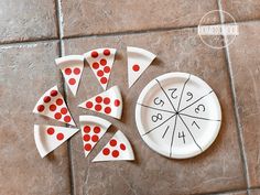 a white plate topped with slices of pizza on top of a tile floor covered in red dots