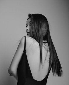 black and white photograph of a woman with her back to the camera, wearing a bra