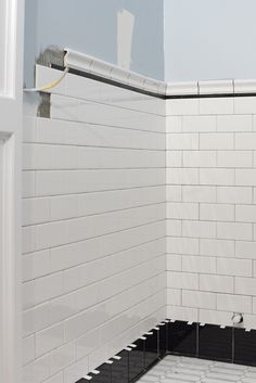 a bathroom with white and black tiles on the walls