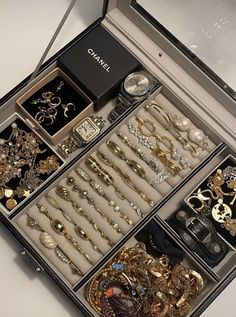 an open jewelry box filled with lots of different types of brooches and bracelets